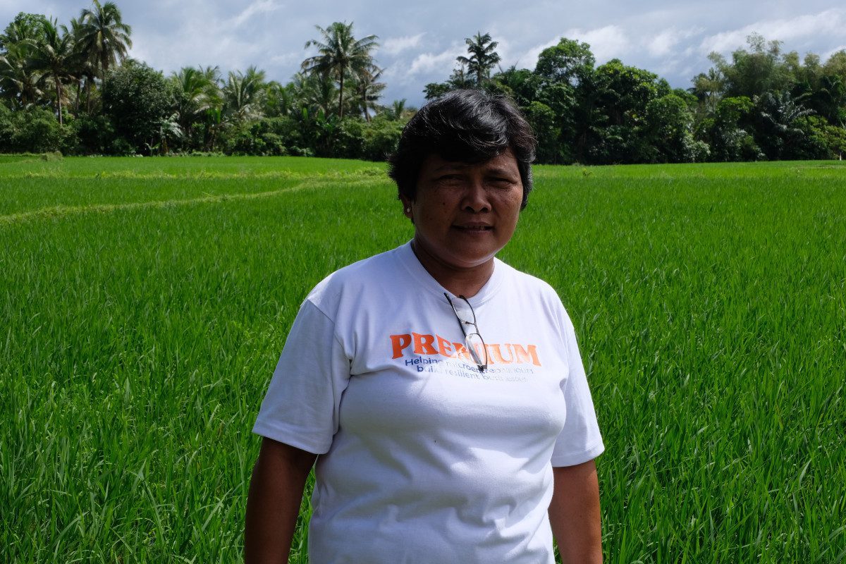 Benilda in front of her rice paddy