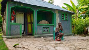 Haïti : femme assise devant sa maison | Haiti: a woman in front of her house