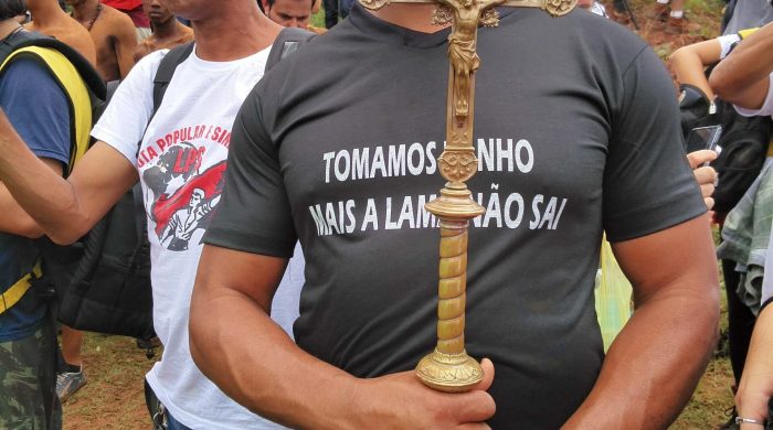 Manifestant au Brésil porte un t-shirt sur lequel on peut lire : "Nous nous sommes baignés, mais la boue ne s'est pas enlevée". | A protestor wears a t-shirt that reads, “We bathed, but the mud didn’t come off.”